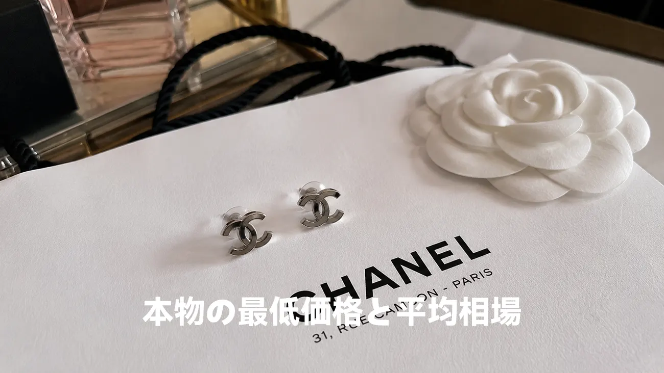 白いショップ袋と山茶花の横に置かれたシンプルなココマークピアス