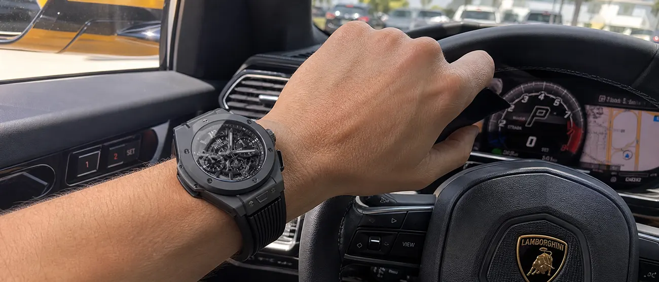 愛車のハンドルを握る手元に映えるウブロ ビッグバンのスマホ実写